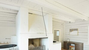 A room with a fireplace, a bench, and a rustic wooden wall. - 6 Person Holiday Home in Hova (Hova)