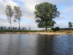 A calm river with trees and a clear sky. - 6 Person Holiday Home in Hova (Hova)