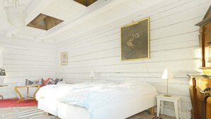 A room with a large bed, a wooden headboard, a small bedside table, a lamp, and a painting on the wall. - 6 Person Holiday Home in Hova (Hova)