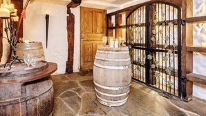 Ein rustikales Interieur mit Steinfußboden, Holzbottichen und einem schmiedeeisernen Tor.