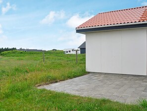 A building with a red-tiled roof and a paved pathway leading to it. - Lovely Holiday Home in Jutland with Hot Tub (Harboore)