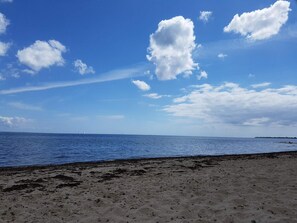 A beach with a clear sky and calm sea.
