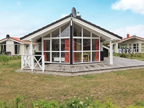 A modern house with a large glass front, a deck, and a satellite dish. - Holiday Home in GrÃ¶mmitz (Groemitz)