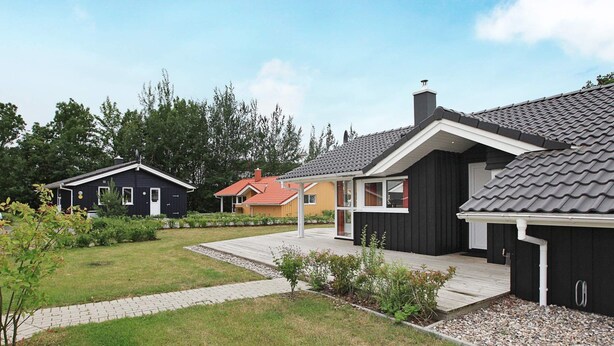 A residential area with multiple houses, a paved driveway, and a grassy lawn. - Holiday Home in GrÃ¶mmitz (Groemitz)
