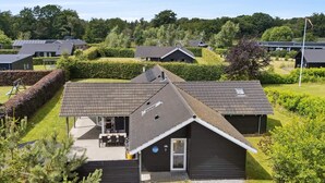 A modern house with a sloped roof, a visible garage, and a well-maintained lawn. - 5 Star Holiday Home in Ebeltoft (Ebeltoft)