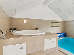 A modern bathroom with a freestanding bathtub, a shower area, and a built-in pool. - 5 Star Holiday Home in Ebeltoft (Ebeltoft)
