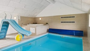 An indoor swimming pool with a blue slide, a yellow ball, and a jacuzzi. - 5 Star Holiday Home in Ebeltoft (Ebeltoft)