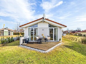 A single-story house with a deck, large windows, and a satellite dish. - Holiday Home in GrÃ¶mmitz (Groemitz)