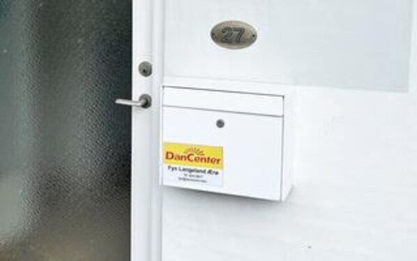 A door with a DanCenter sign, a lock, and a number plate.