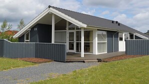 A modern house with a sloped roof, large windows, and a number 23 on the side. - 4 Star Holiday Home in Otterup (Otterup)