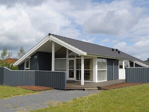 A modern house with a sloped roof, large windows, and a number 23 on the side. - 4 Star Holiday Home in Otterup (Otterup)