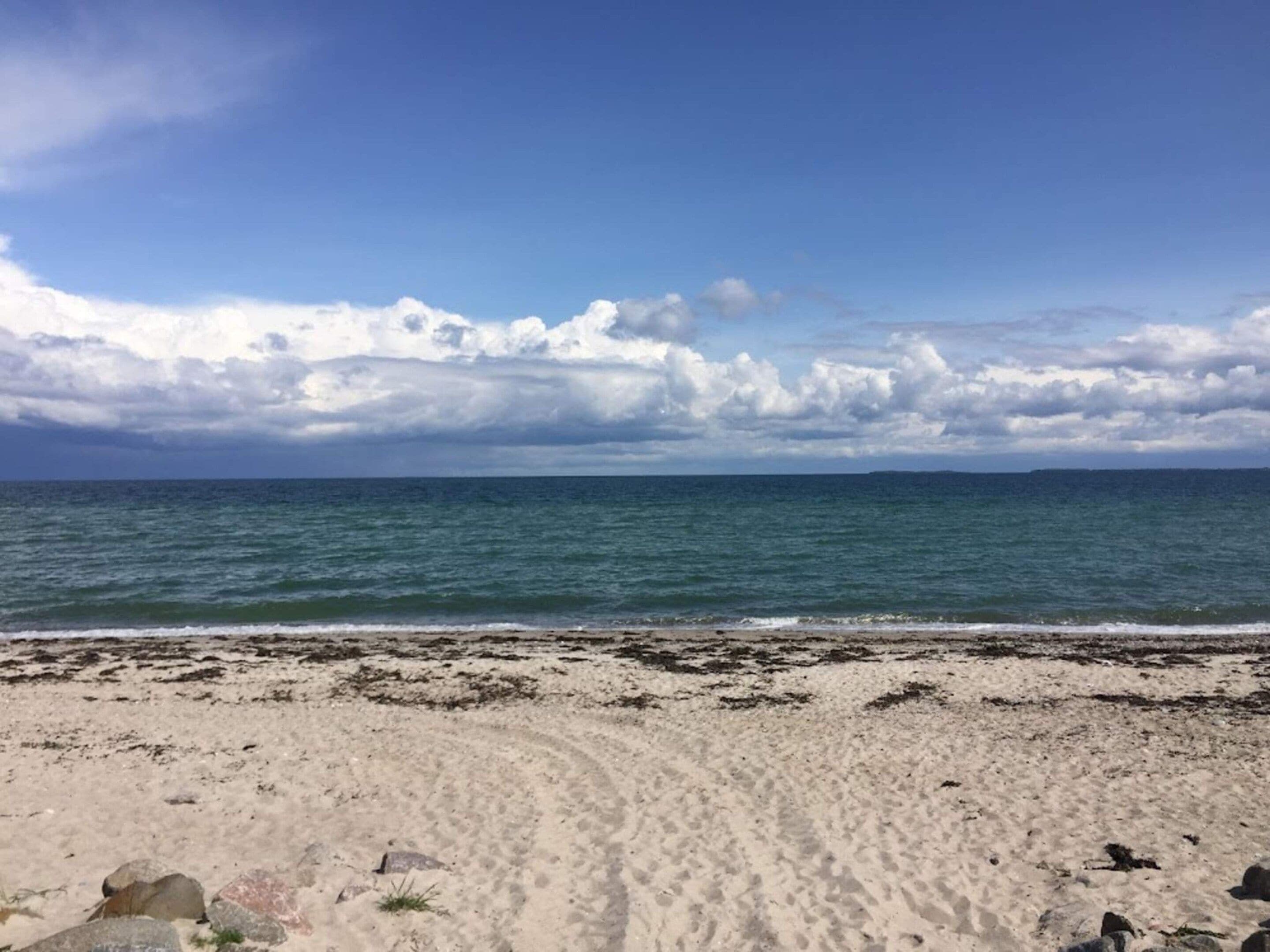 A beach with a clear sky and calm sea.