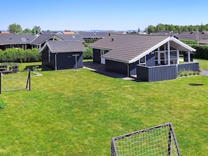A residential area with multiple houses, each featuring a distinct architectural style with pitched roofs and large windows.