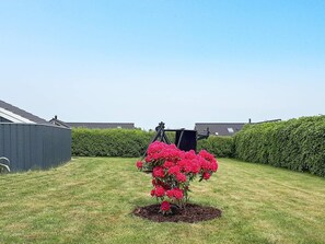 A garden with a flower bed and a shed. - 4 Star Holiday Home in Otterup (Otterup)