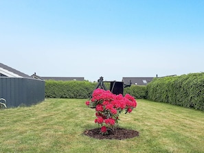 A garden with a flower bed and a shed. - 4 Star Holiday Home in Otterup (Otterup)