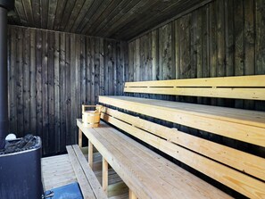 A sauna with wooden benches and a wooden wall. - 5 Star Holiday Home in Brovst (Brovst)