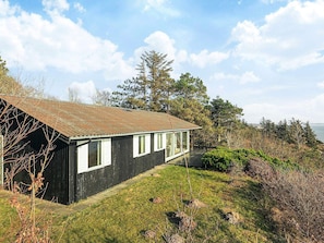 A single-story building with a sloped roof, large windows, and a grassy yard. - 6 Person Holiday Home in Spottrup (Spøttrup)