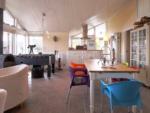 A cozy indoor space with a foosball table, a dining area with chairs, and a kitchen area with cabinets. - 5 Star Holiday Home in Jaegerspris (Jægerspris)