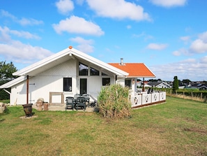 A single-story white house with a red-tiled roof, a covered porch, and a grassy yard. - 5 Star Holiday Home in Jaegerspris (Jægerspris)