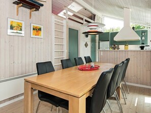 A dining area with a wooden table, black chairs, and a red tray. - 4 Star Holiday Home in Ebeltoft (Ebeltoft)