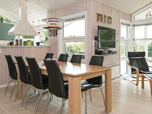A modern kitchen with a dining area, wooden flooring, and a large window. - 4 Star Holiday Home in Ebeltoft (Ebeltoft)