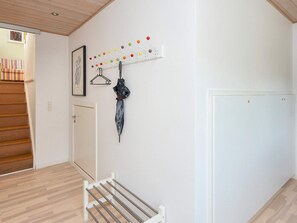A hallway with a coat rack, a door, and a bench. - 4 Star Holiday Home in Bjert (Bjert)