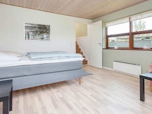 A bedroom with a bed, a window, a radiator, and a staircase. - 4 Star Holiday Home in Bjert (Bjert)