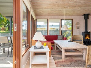 A cozy living area with a sofa, a table, a lamp, and a fireplace. - 4 Star Holiday Home in Bjert (Bjert)
