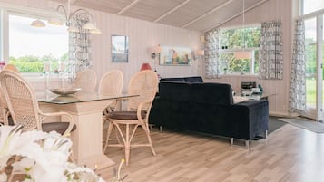 Decoração moderna com área de refeições, assentos e vista através de grandes janelas.