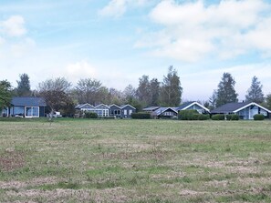 A row of houses with a grassy field in the foreground. - 4 Star Holiday Home in Nysted (Nysted)