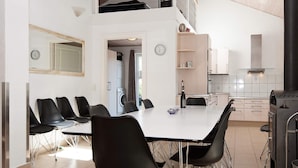 Una cocina moderna con comedor, que incluye una mesa con sillas, horno empotrado y lavadora.
