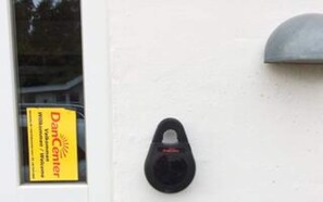 A door with a yellow sign and a black intercom.