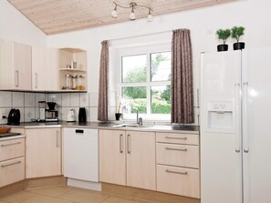 A modern kitchen with light wood cabinets, a white dishwasher, a coffee maker, and a water dispenser. - 5 Star Holiday Home in Ega (Aarhus)