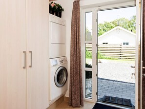A laundry room with a washing machine, a drying rack, and a door leading outside. - 5 Star Holiday Home in Ega (Aarhus)