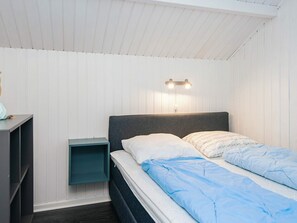 A bedroom with a bed, a nightstand, and a wall-mounted light fixture. - 6 Person Holiday Home in Toftlund (Toftlund)