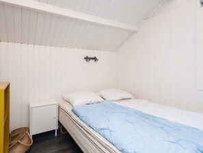 A small, neatly organized bedroom with a single bed, a nightstand, and a wall-mounted lamp. - 6 Person Holiday Home in Toftlund (Toftlund)