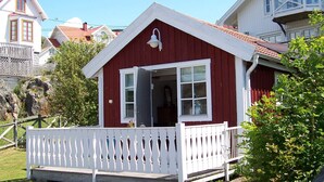 A red and white house with a white porch and a small balcony. - 4 Person Holiday Home in Ronnang (Roennaeng)