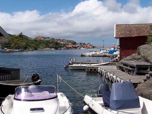 A marina with boats docked, a wooden pier, and a red building. - 4 Person Holiday Home in Ronnang (Roennaeng)