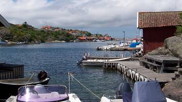 A marina with boats docked, a wooden pier, and a red building.