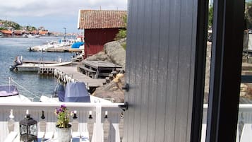 Een balkon met uitzicht op een haven, inclusief boten en een rood gebouw.