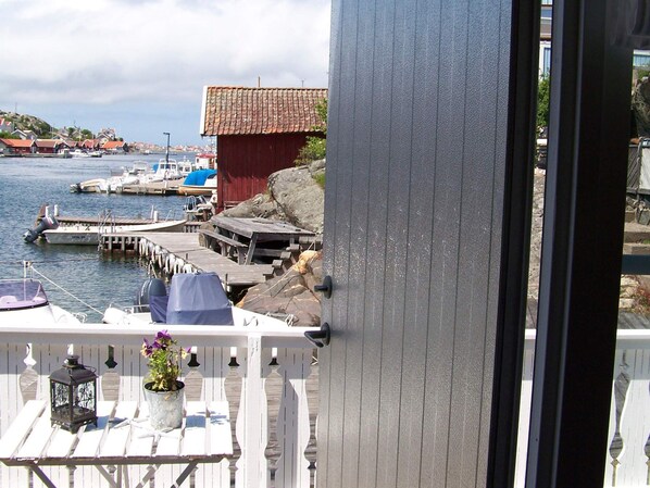 A balcony with a view of a harbor, including boats and a red building. - 4 Person Holiday Home in Ronnang (Roennaeng)