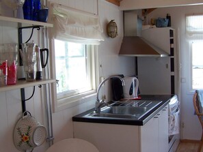 A compact kitchen with a sink, a kettle, and a stove. - 4 Person Holiday Home in Ronnang (Roennaeng)