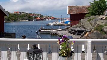 A waterfront view with a dock, boats, and a red building.