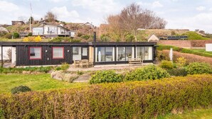 A modern house with a flat roof, large windows, and a garden. - 6 Person Holiday Home in Borkop (Borkop)