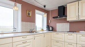 A kitchen with white cabinets, a stainless steel sink, and pendant lighting. - 6 Person Holiday Home in Harboore (Harboore)