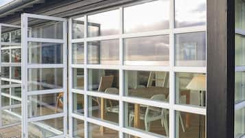 A modern building with large windows and a view of an outdoor patio area.