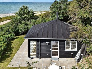 A black house with a sloped roof, a front door, and a window. - 4 Star Holiday Home in Martofte (Martofte)