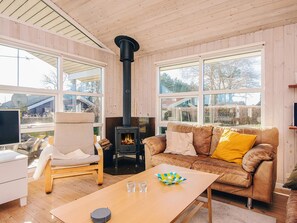A cozy living room with a sofa, a table, and a fireplace.