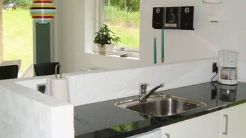 A kitchen with a built-in dishwasher, a sink, and a window with a view of the outdoors.