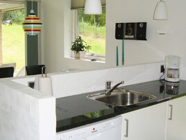 Una cocina con lavavajillas integrado, un lavabo y una ventana con vistas al exterior.